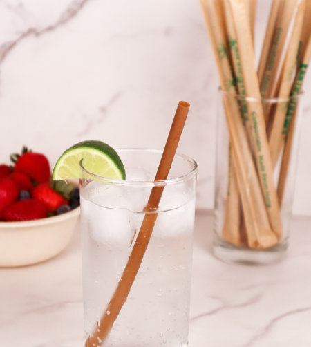 8-inch standard brown hemp straw in a water glass with lime and wrapped straws in the background